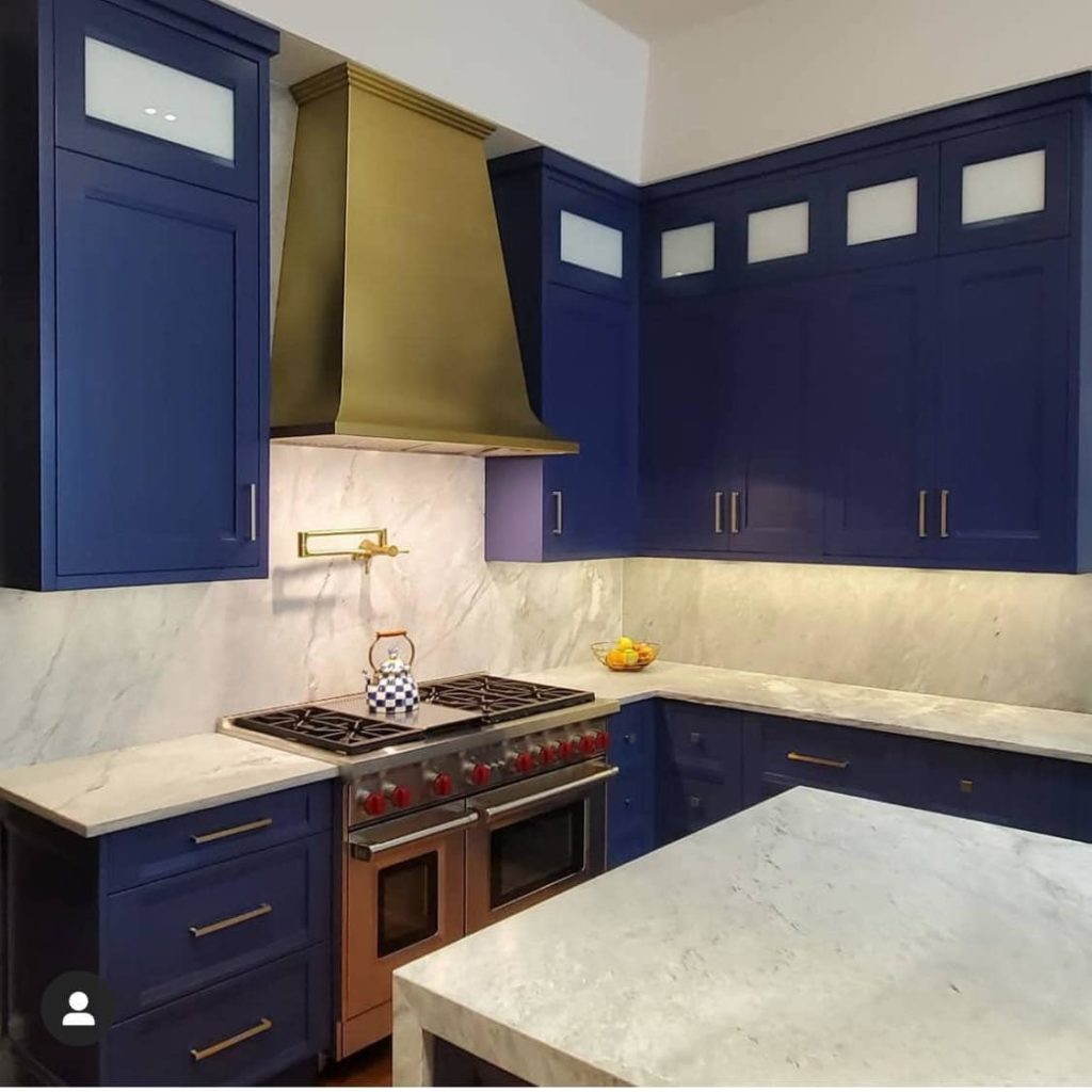 blue kitchen with gold range hood