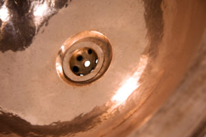 Detail of copper round sink. Brown copper sink in retro style. Antique sink for home. Macro shooting.