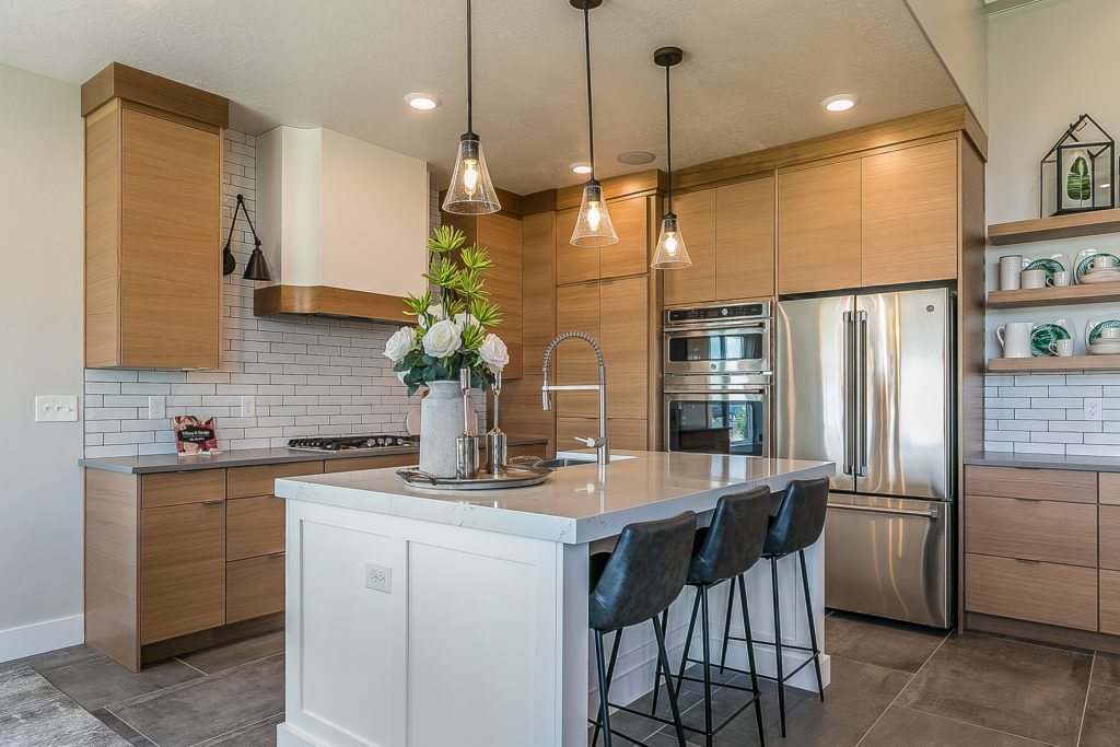 Sleek white kitchen island amongst modern light brown cabinetry